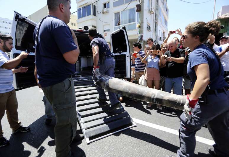 <p>Policiais&nbsp;especialistas em explosivos carregam&nbsp;os restos de um foguete em uma van, depois de o mesmo ter sido interceptado pelo sistema de defesa a&eacute;rea de Israel &quot;Iron Dome&quot;, em Tel Aviv, nesta sexta-feira, 11 de julho</p>