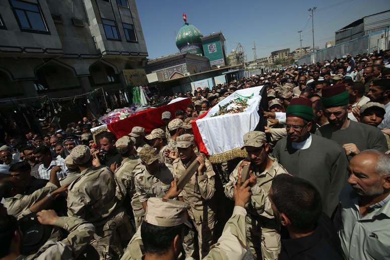 <p>Iraquianos carregam os caix&otilde;es de mortos em combates, na cidade mu&ccedil;ulmana predominantemente sunita de Samarra, durante o seu funeral,&nbsp;na cidade sagrada de Karbala, a 80 km ao sul de Bagd&aacute;, neste s&aacute;bado, 12 de julho</p>
