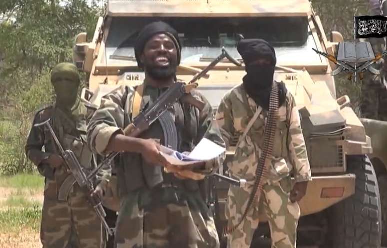 <p>Trecho do vídeo, obtido em 13 de julho, divulgado pelo grupo extremista islâmico nigeriano Boko Haram, mostra o líder do grupo, Abubakar Shekau (ao centro) manifestando apoio ao sunita Estado Islâmico (EI), do Iraque</p>