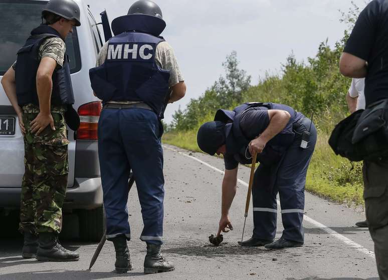 <p>Um oficial inspeciona parte de um morteiro, de 120 milímetros, na aldeia ucraniana oriental de Semenovka, neste domingo, 13 de julho</p>