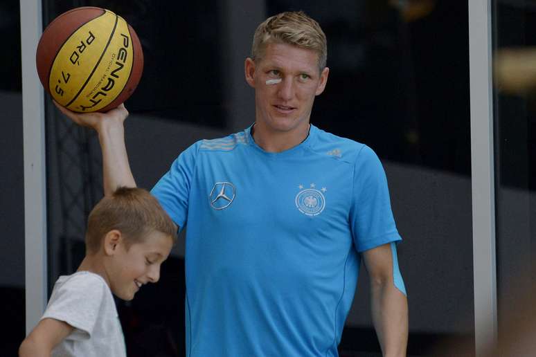 Com curativo no rosto, Schweinsteiger brinca com bola de basquete