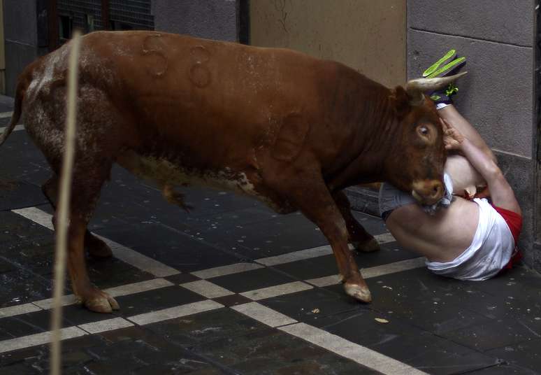 <p>Um homem é chifrado por um touro nas ruas de Pamplona, em 14 de julho, durante o Festival de São Firmino</p>