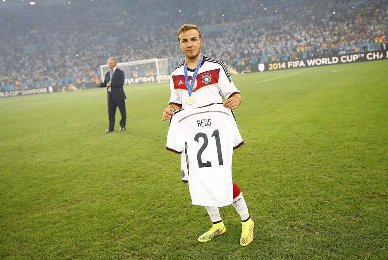 <p>Autor do gol do título, Götze segura a camisa do companheiro Reus, cortado da Copa do Mundo</p>