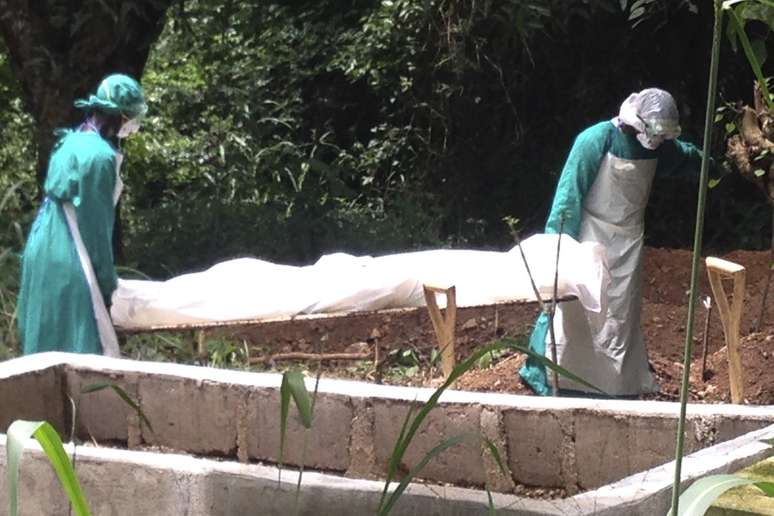<p>Profissionais de saúde carregam o corpo de uma vítima do Ebola em Kenema, Serra Leoa, em 25 de junho</p>