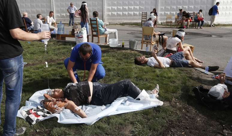 <p>Paramédicos atendem passageiros feridos em vários vagões do metrô que descarrilaram em Moscou, nesta terça-feira, 15 de julho</p>