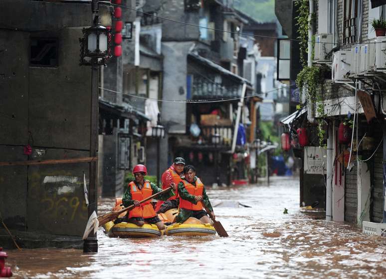 <p>Equipes de resgate procuram pessoas por uma rua inundada, após chuvas fortes atingirem a cidade antiga de Fenghuang County, província de Hunan, nesta quarta-feira, 16 de julho</p>