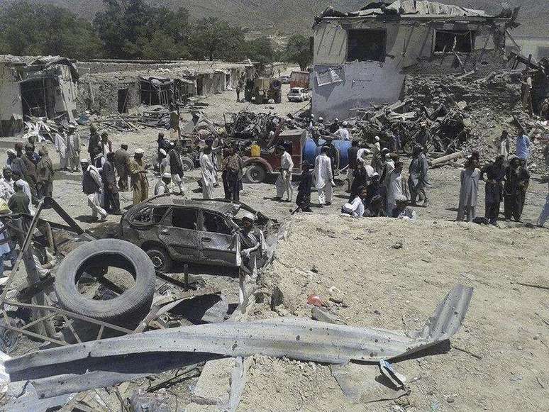 <p>Pessoas se aglomeram ao redor do local em que um carro-bomba explodiu, na província de Paktika</p>