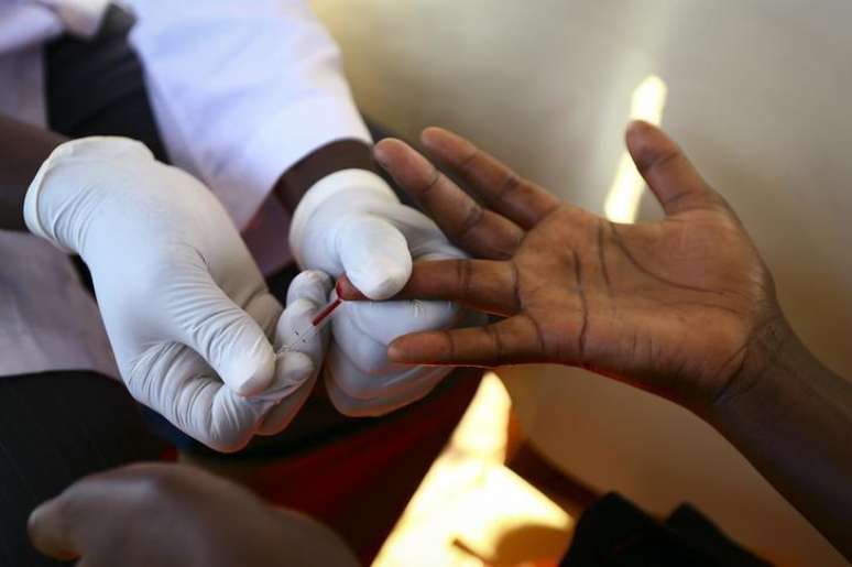 Médico retira amostra de sangue de um homem para exame de HIV/AIDS em um laboratório móvel, em Ndeeba, subúrbio de Kampala, capital de Uganda. 16/05/2014.