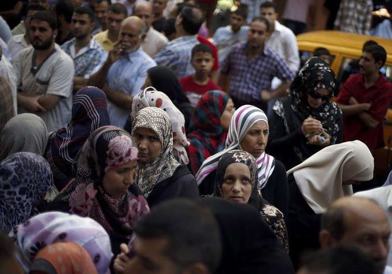 <p>Palestinos se aglomeram em frente a um banco de Gaza para sacar dinheiro durante uma trégua humanitária de cinco horas por Israel</p>