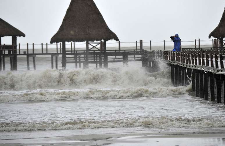 Homem filma fortes ondas no sul da província de Hainan, na China, enquanto o tufão Rammasun se aproxima do local