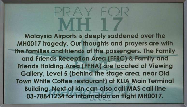 Mensagem pedindo orações para o voo MH17 é exibida em painel no Aeroporto Internacional de Kuala Lumpur