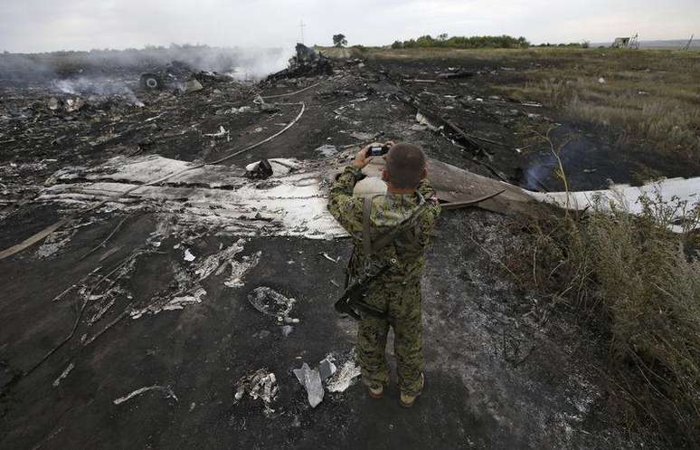 <p>Um separatista pró-Rússia armado tira foto do local onde o avião da Malaysia Airlines caiu</p>