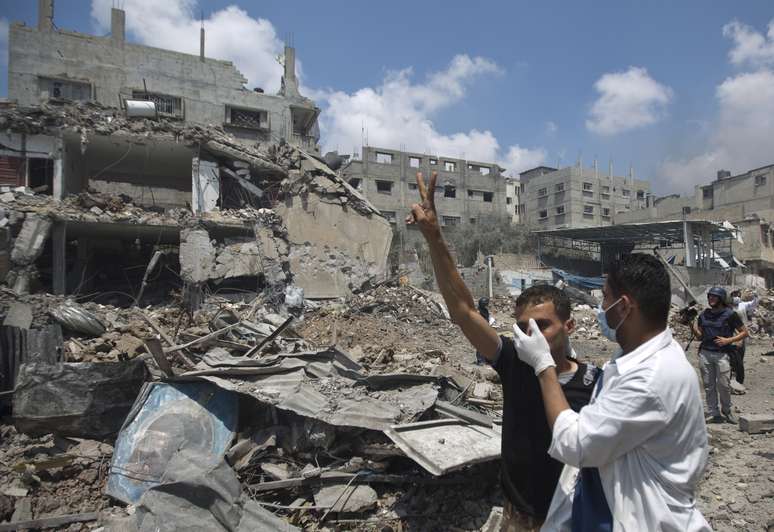 Socorrista ajuda sobrevivente palestino após ataque israelense em Gaza