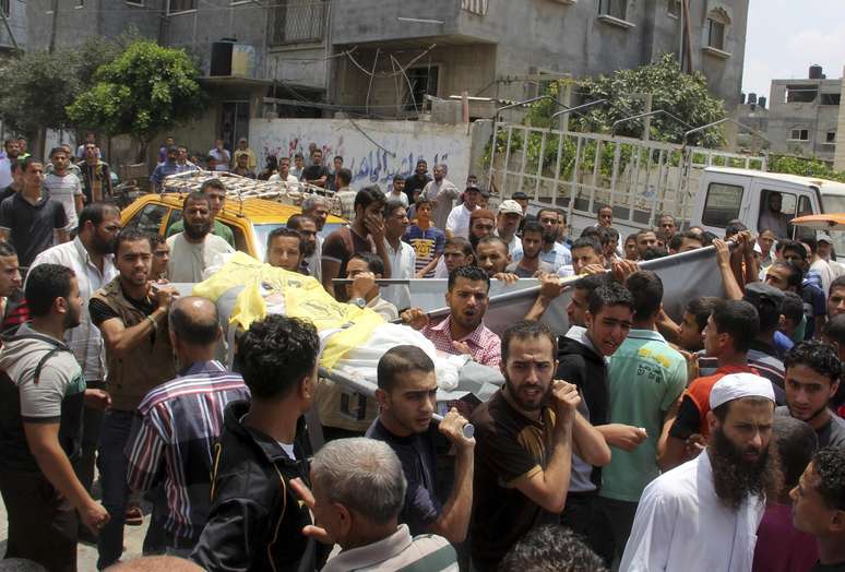 Palestinos carregam corpos de irmãos mortos durante bombardeio em sua casa de Rafah, no sul da Faixa de Gaza