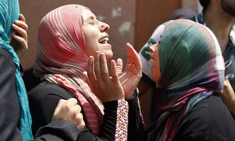 Mulheres palestinas choram a morte de parente por forças israelenses nesta segunda-feira