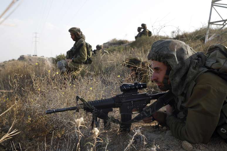 Soldados israelenses se posicionam com armas na cidade de Sderot durante infiltração na Palestina nesta segunda-feira
