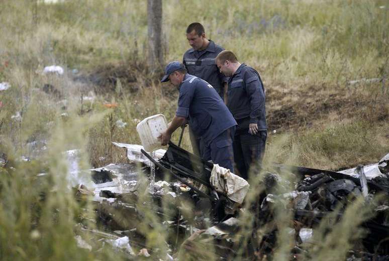 <p>Membros do Ministério de Emergências da Ucrânia trabalham no local do acidente do avião da Malaysia Airlines na Ucrânia</p>