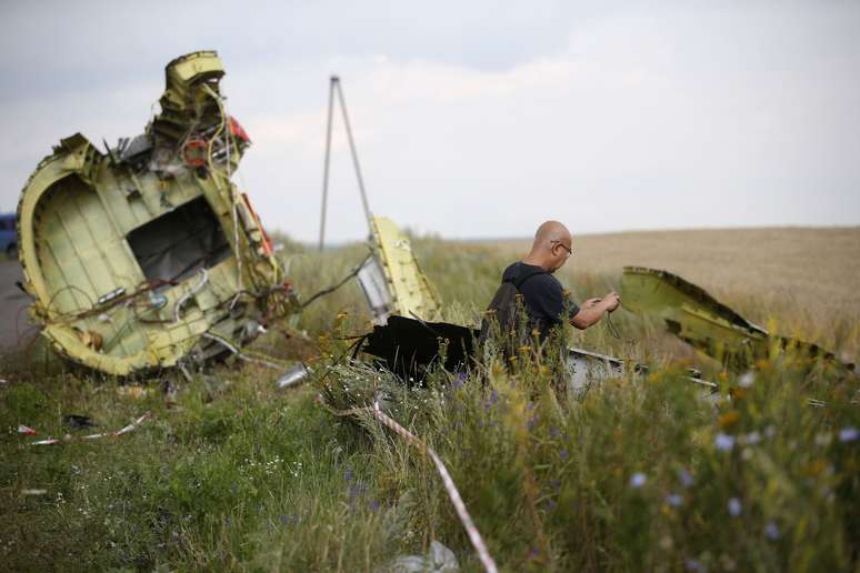 <p>Um investigador de acidentes aéreos da Malásia inspeciona o local da queda do Boeing que fazia o voo MH17, perto da aldeia de Hrabove, região de Donetsk, leste da Ucrânia, em 22 de julho</p>
