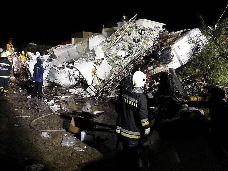 <p>Bombeiros observam destroços do avião da TransAsia Airways nas ilhas Penghu, em 23 de julho</p>