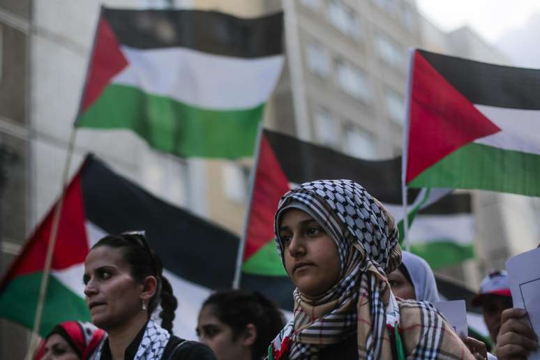 <p>Mulheres carregam uma bandeira da Palestina durante protesto contra os ataques de Israel &agrave; Faixa de Gaza&nbsp;em Berlim, em 22 de julho</p>