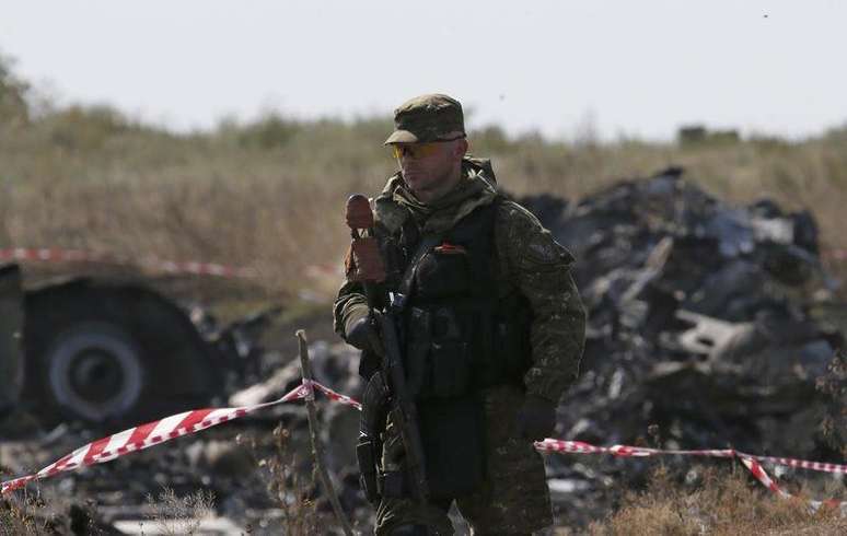 Um separatista armado pró-russo protege o local da queda de um avião da Malaysia Airlines, na região de Donetsk, no leste da Ucrânia, nesta quinta-feira. 24/07/2014