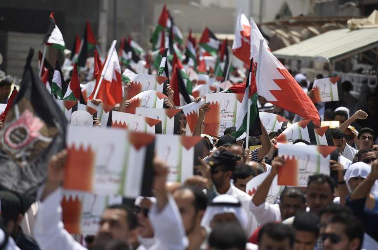 <p>Manifestantes segurando bandeiras do Bahrein e da Palestina&nbsp;marcham durante um protesto contra a a&ccedil;&atilde;o militar de Israel em Gaza, ao oeste de Manama, em 25 de julho</p>