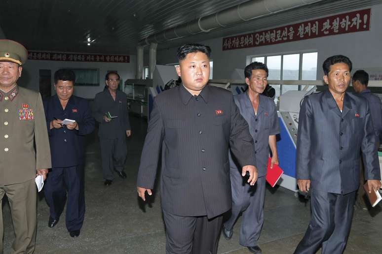 <p>L&iacute;der norte-coreana Kim Jong-un (centro) &eacute; visto em uma f&aacute;brica no pa&iacute;s</p>