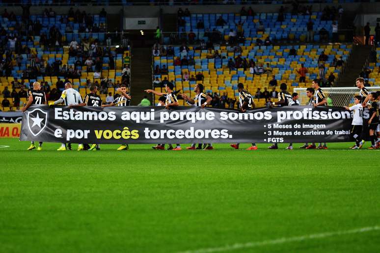 Jogadores do Botafogo carregam faixa de protesto no Maracanã