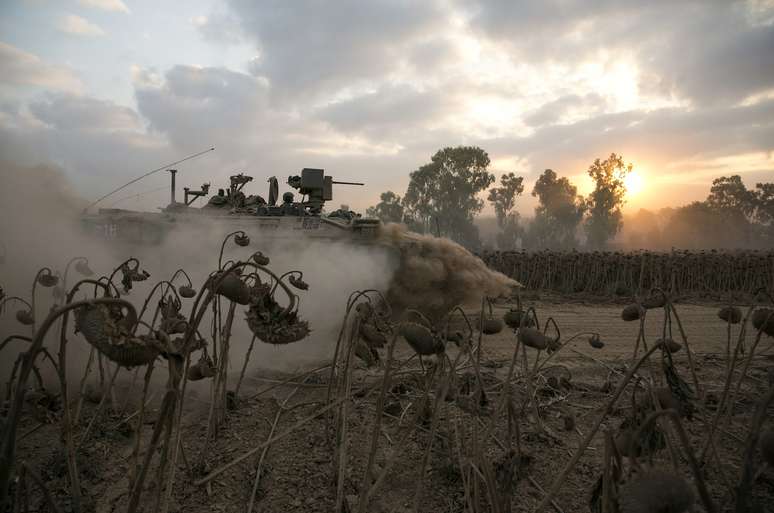 <p>Soldado israelense dirige&nbsp;ve&iacute;culo blindado depois de atravessar de volta para Israel a partir de Gaza, nesta segunda-feira</p>