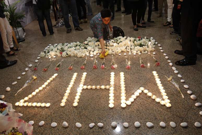 <p>Uma mulher deixa uma flor perto de um memorial  feito em homenagem às vítimas do voo MH17 da Malaysia Airlines, em Kelana Jaya, Malásia, em 25 de julho</p>