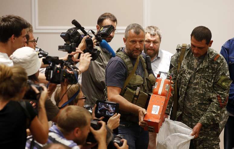 <p>Um separatista pró-Rússia mostra a jornalistas uma caixa-preta pertencente ao voo MH17 da Malaysia Airlines, antes de sua entrega aos representantes da Malásia, em Donetsk, em 22 de julho</p>