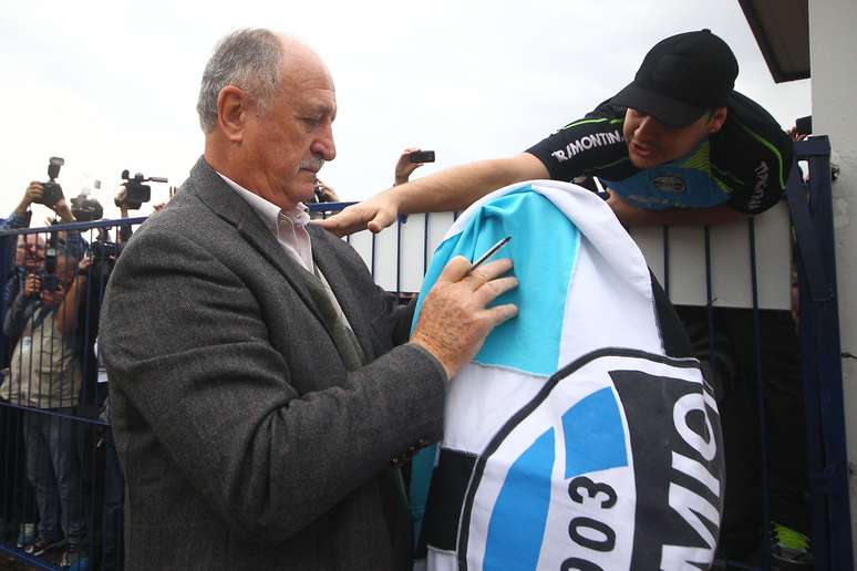 <p>Felipão deu autógrafos em bandeiras do Grêmio e foi aplaudido por torcedores</p>