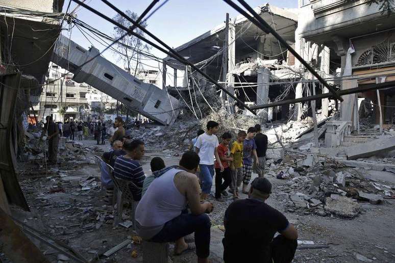<p>Palestinos observam os destro&ccedil;os da torre de uma mesquita que, segundo policiais, foi destru&iacute;da por ataque a&eacute;reo israelense, na Faixa de Gaza, nesta quarta-feira</p>