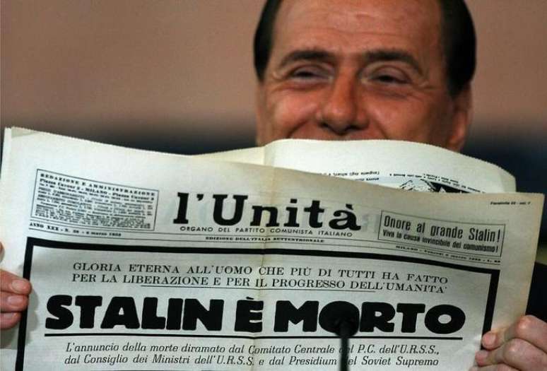 <p>Ex-premiê italiano Silvio Berlusconi lê uma edição comemorativa do díario comunista italiano L'Unitá em que foi anunciada a morte do líder soviético Joseph Stalin, em 23 de dezembro de 2005</p>