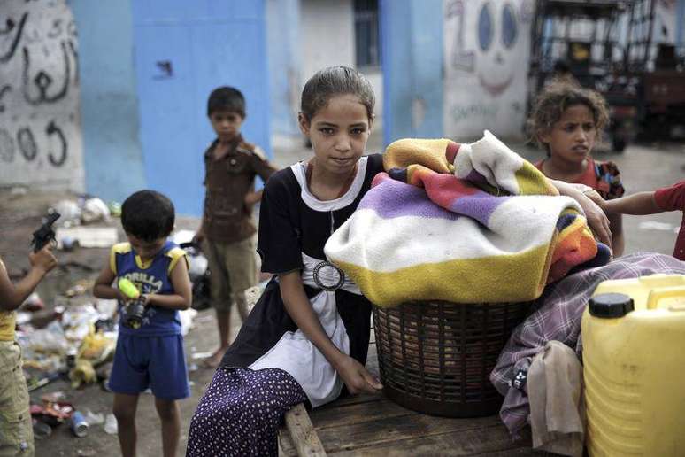 Crianças palestinas no lado de fora de uma escola da ONU que serve de abrigo para moradores que fugiram de suas casas durante operação terrestre israelense, em Jabaliya, no norte da Faixa de Gaza, nesta terça-feira. 29/07/2014