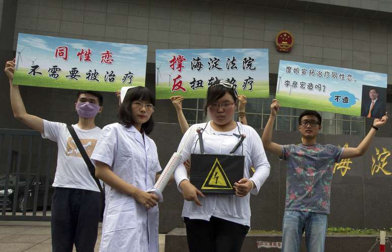 <p>Ativistas dos direitos dos gays posam para jornalistas durante protesto do lado de fora de um tribunal onde o primeiro processo judicial na China envolvendo a chamada terapia de conversão é realizada em Pequim, em 31 de julho</p>