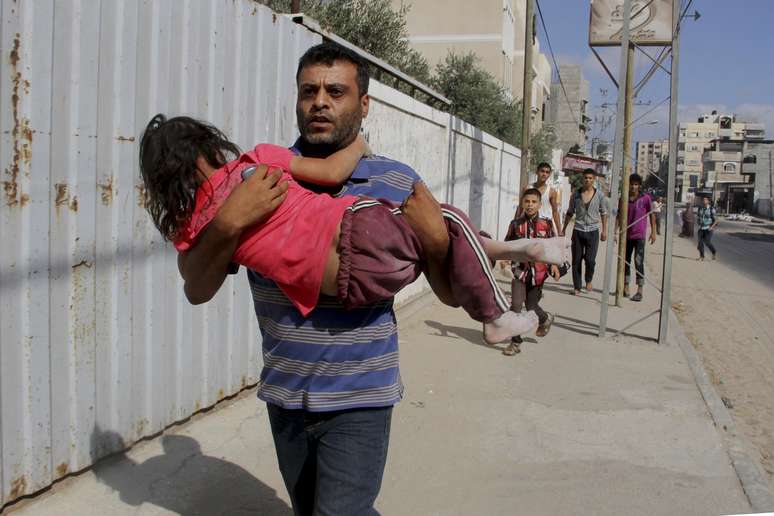 <p>Um palestino carrega sua filha durante fuga logo&nbsp;ap&oacute;s um ataque a&eacute;reo israelense contra um pr&eacute;dio&nbsp;em Rafah, em&nbsp;31 de julho</p>