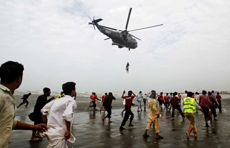 <p>Helicóptero da Marinha do Paquistão retira o corpo de uma vítima que se afogou na praia de Clifton, em Karachi, no Paquistão, nesta quinta-feira, 31 de julho</p>