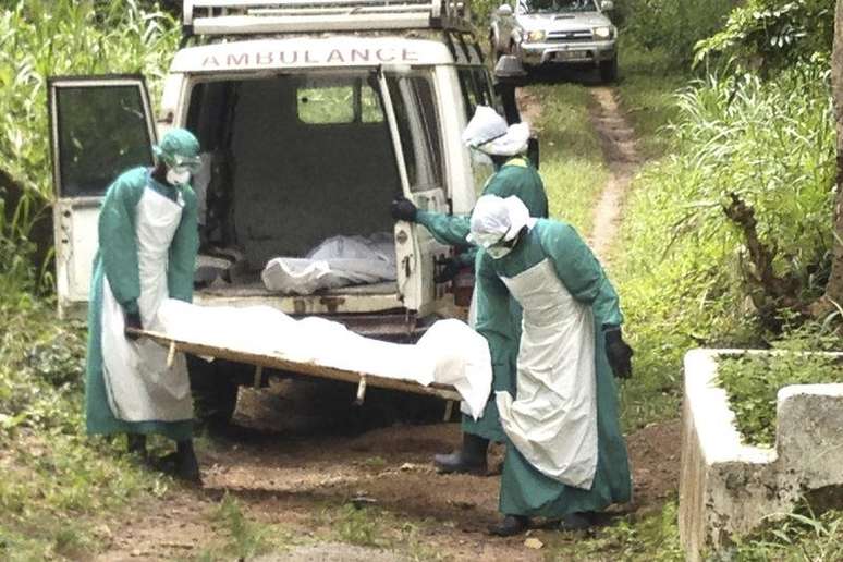 <p>Funcion&aacute;rios da &aacute;rea m&eacute;dica carregam corpo de v&iacute;tima do Ebola em Serra Leao</p>