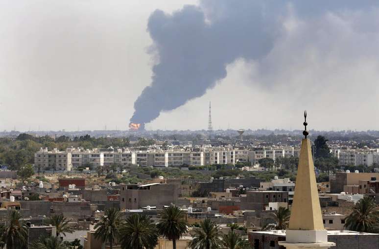 <p>Uma coluna de fumaça é vista no horizonte durante um incêndio em um depósito de óleo atingido durante batalhas entre milícias rivais, em Tíipoli, em 28 de julho</p>