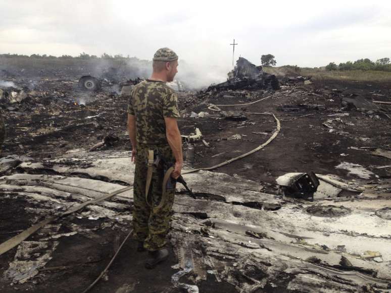 <p>Separatista pró-Rússia observa o local da queda do Boeing 777 da Malaysia Airlines na região de Donetsk, em 17 de julho</p>