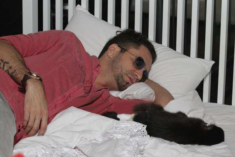 Latino dorme com seu macaco em intervalo de gravação
