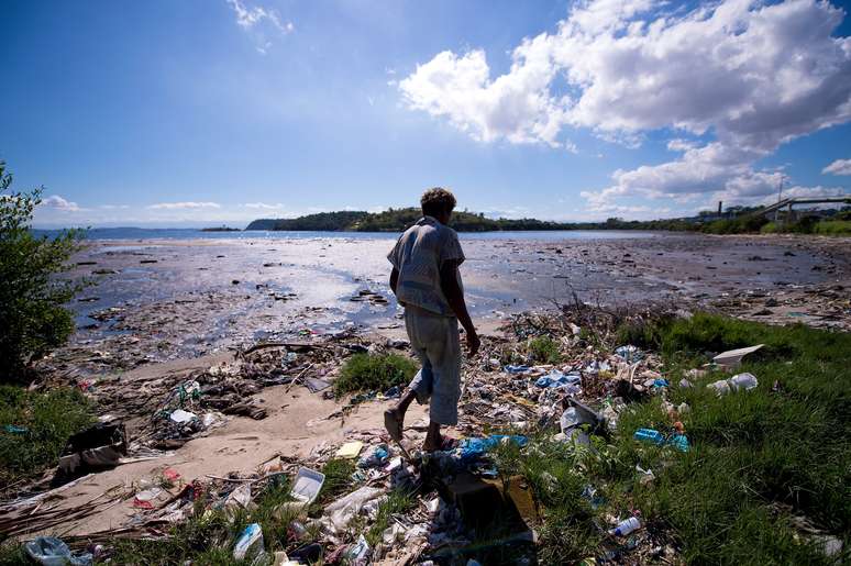 <p>Homem caminha sobre o lixo &agrave; beira da Ba&iacute;a de&nbsp;Guanabara</p>