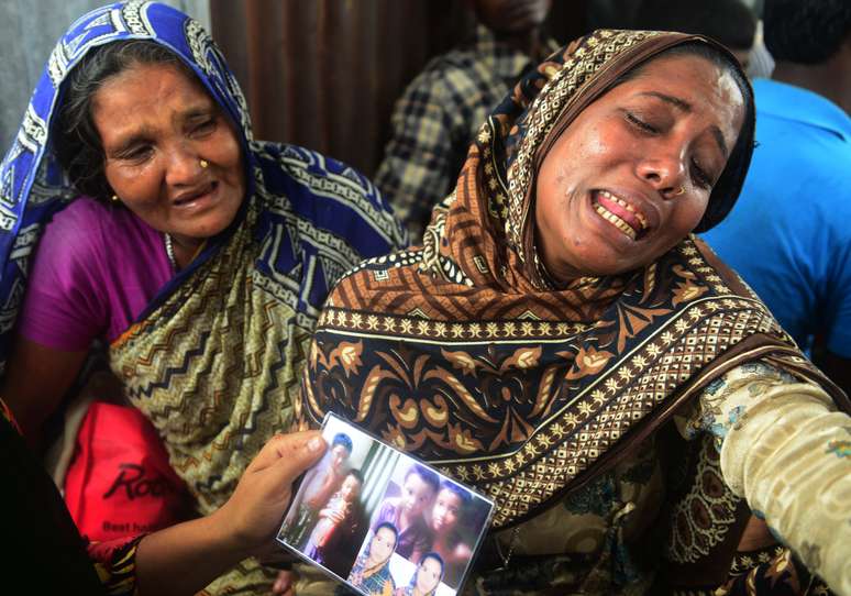 Mulher chora por ter irmão desaparecido em acidente com embarcação em Bangladesh