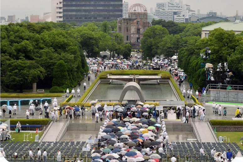 Pessoas enfrentam a chuva para orar pelas vítimas do ataque atômico