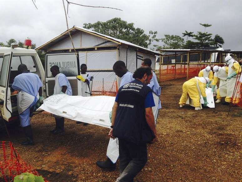 <p>Voluntários carregam corpos em um centro liderado pelo grupo Médico Sem Fronteiras para pacientes com Ebola, em Kailahun, Serra Leoa, em 2 de agosto</p>