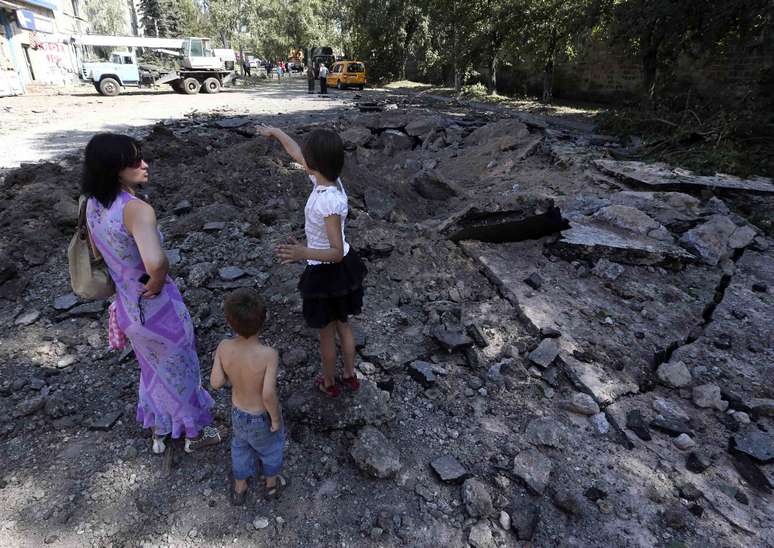 Alguns moradores de Donetsk observam estragos dos conflitos na cidade nesta quarta-feira