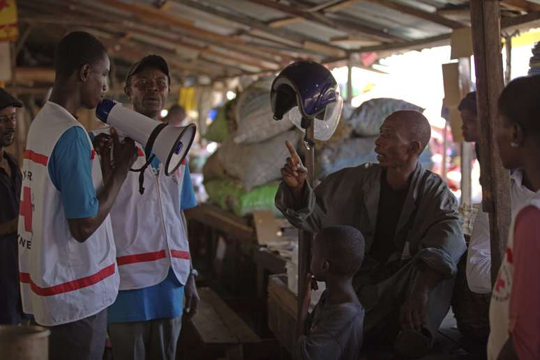 <p>Trabalhadores do Unicef e parceiros orientam famílias sobre como podem proteger-se da doença do vírus Ebola, no Marche Níger, um mercado em Conakry, Guiné</p>