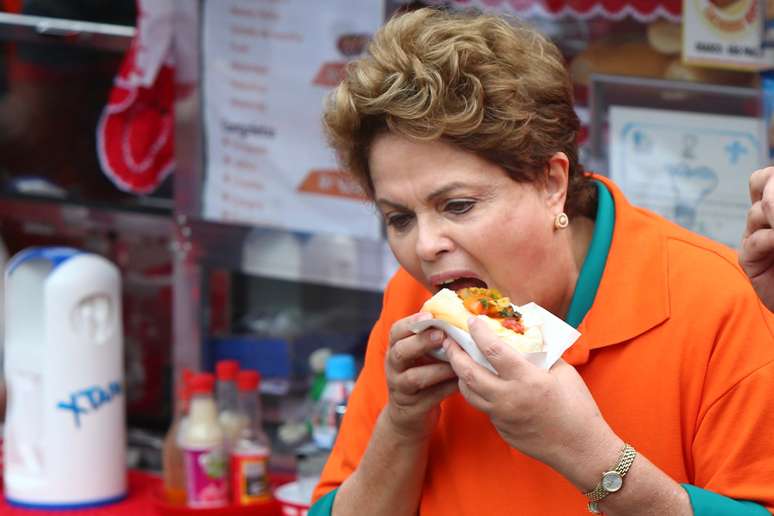 Presidente e candidata à reeleição pelo PT, Dilma Rousseff come cachorro-quente em Osasco, na região metropolitana de São Paulo, durante agenda de campanha na cidade