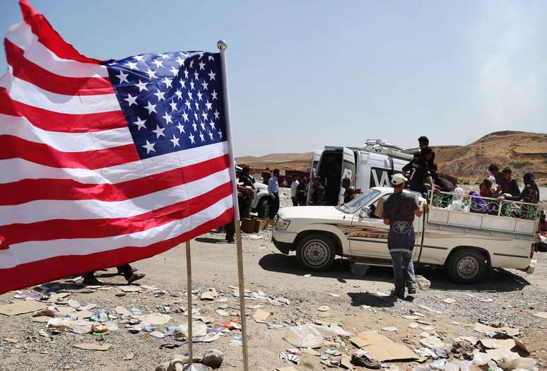 <p>Uma bandeira dos Estados Unidos &eacute; vista no local onde&nbsp;iraquianos deslocados da comunidade Yazidi cruzam a fronteira S&iacute;ria-Iraque, na ponte sobre o rio Tigre Feeshkhabour, norte do Iraque. Foto tirada em 10 de agosto</p>